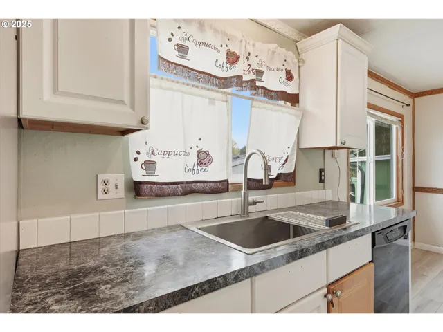 a kitchen with stainless steel appliances granite countertop a sink dishwasher and cabinets with wooden floor