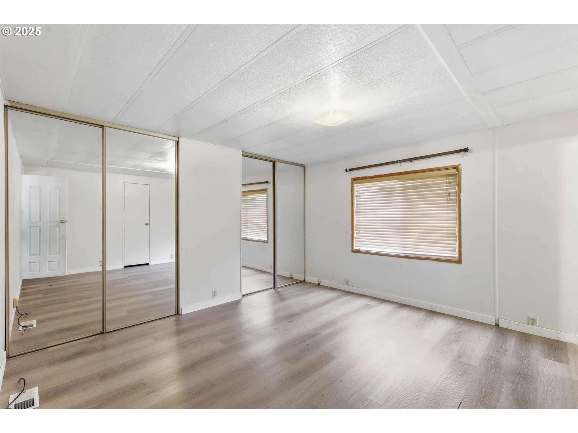 23200 Northeast Sandy Boulevard, Unit 77 Troutdale, OR 97060 - Photo 37 of 43 a view of an empty room with wooden floor & closet