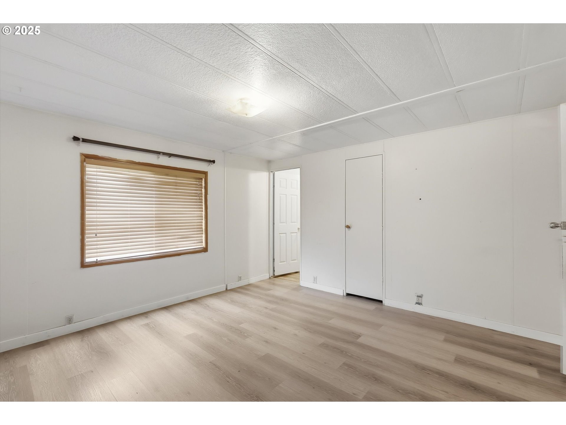 23200 Northeast Sandy Boulevard, Unit 77 Troutdale, OR 97060 - Photo 38 of 43 a view of an empty room with wooden floor and a window