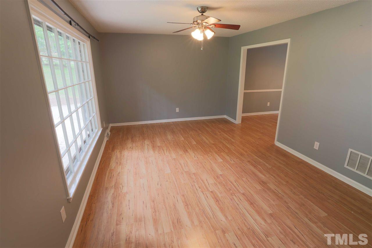 1609 Baker Road Raleigh, NC 27607 - Photo 4 of 22 a view of empty room with wooden floor and fan