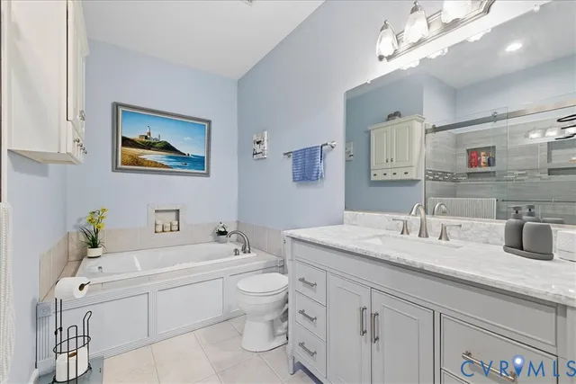 a bathroom with a granite countertop sink mirror vanity and toilet