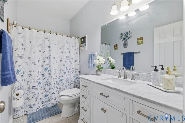 a bathroom with a granite countertop toilet a sink and a mirror