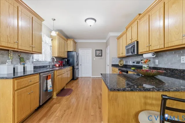 a large kitchen with granite countertop a lot of counter space and wooden floor