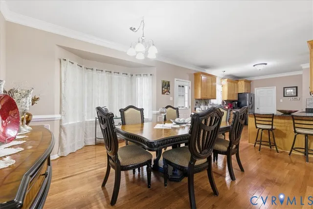 a view of a a dining room with furniture window and wooden floor