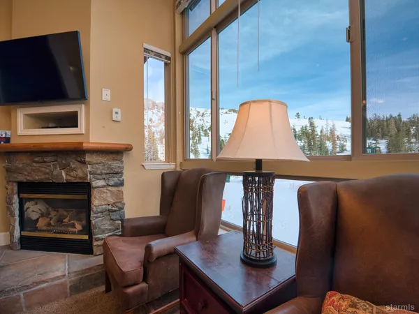 a living room with furniture a flat screen tv and kitchen view
