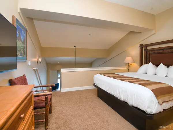 a bedroom with a bed and a potted plant on the table