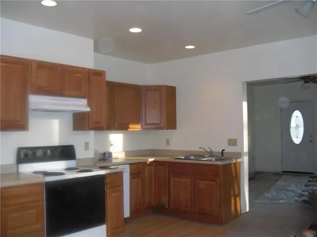 a kitchen with granite countertop a sink and a stove