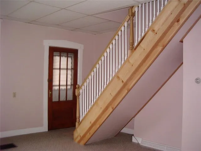 a view of staircase with lots of frames on wall and windows