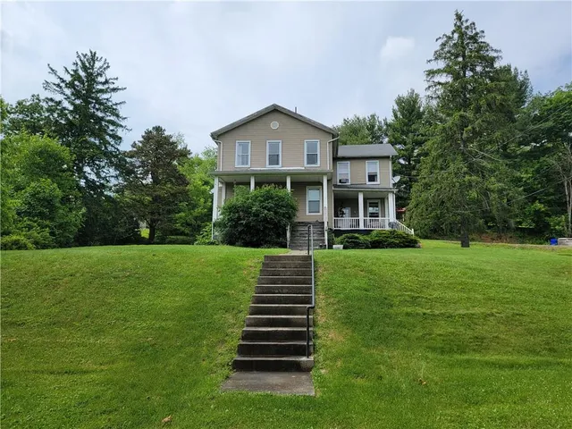 a front view of a house with a yard and garden