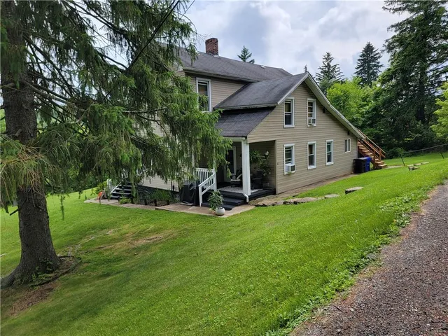 a view of a house with a yard and sitting area