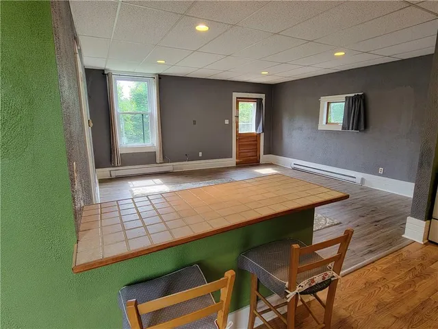 a view of an empty room with window and wooden floor
