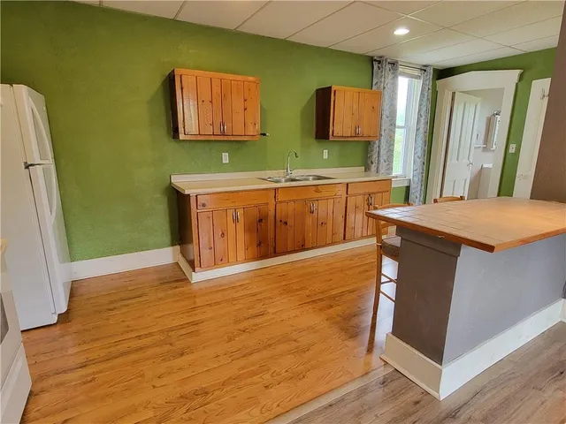 a room with stainless steel appliances white cabinets and wooden floors
