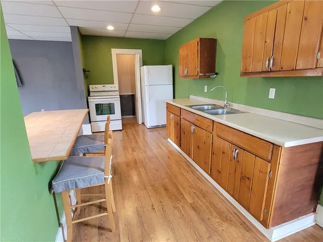 a kitchen with wooden floors sink and cabinets