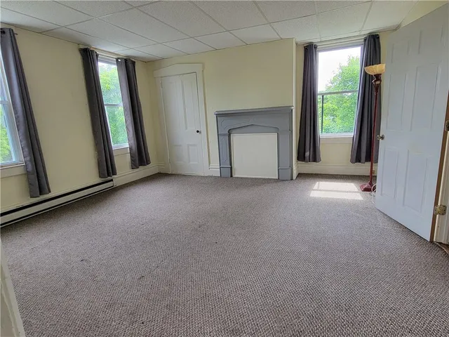 a view of an empty room with a fireplace and a window