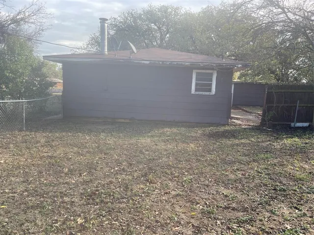 a view of a dry yard with trees