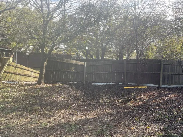 a view of a backyard with large trees