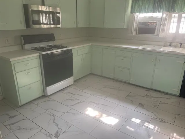 a kitchen with a sink cabinets and a stove top oven