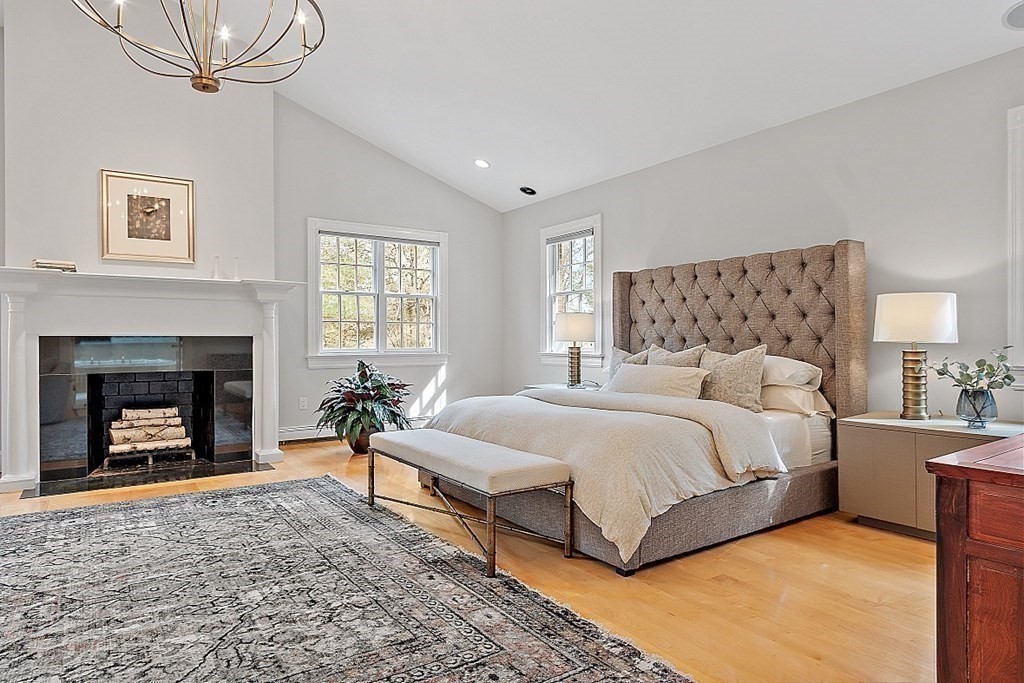451 Wellesley Street Weston, MA 02493 - Photo 22 of 41 a spacious bedroom with a bed and a fireplace