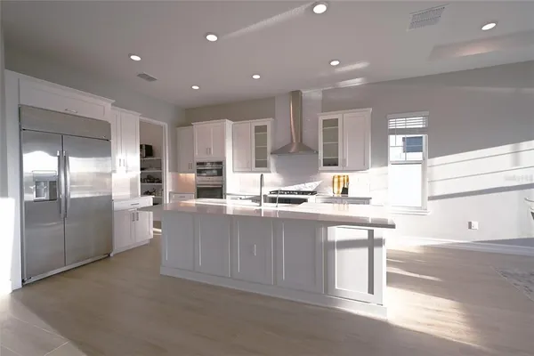 a kitchen with stainless steel appliances granite countertop a sink and a refrigerator