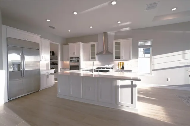 a kitchen with stainless steel appliances granite countertop a sink and a refrigerator