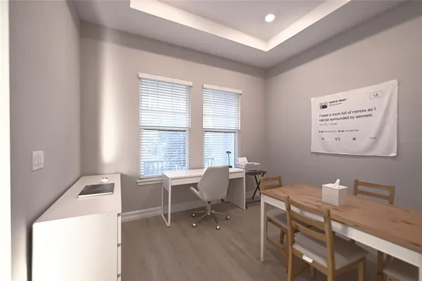 a view of a workspace with furniture and a window