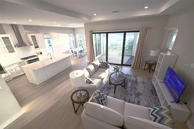 a living room with furniture wooden floor and a large window