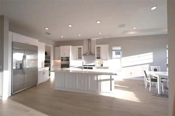 a kitchen with stainless steel appliances kitchen island granite top and refrigerator