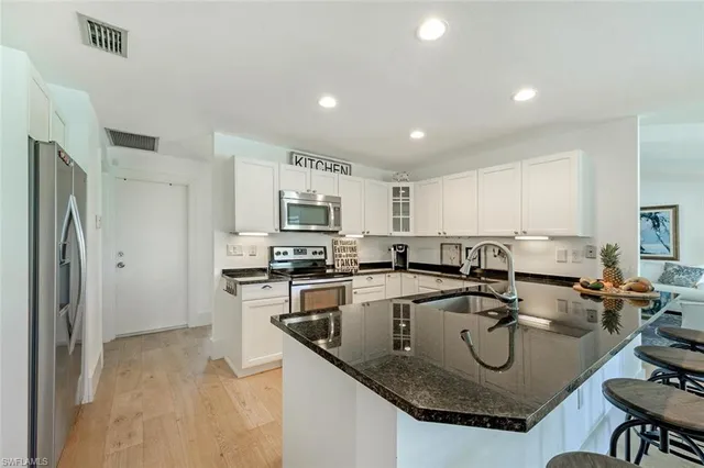 a kitchen with stainless steel appliances granite countertop a sink a stove and refrigerator