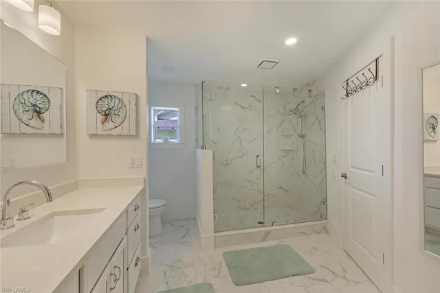 a bathroom with a sink a toilet and shower