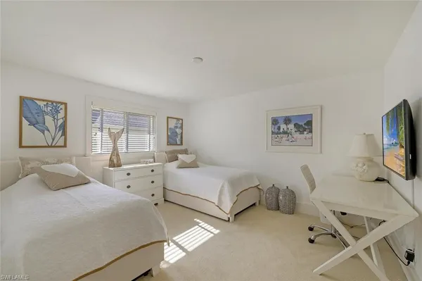 a bedroom with two beds and a table