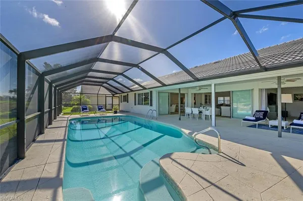 a view of a patio with table and chairs with wooden floor and fence