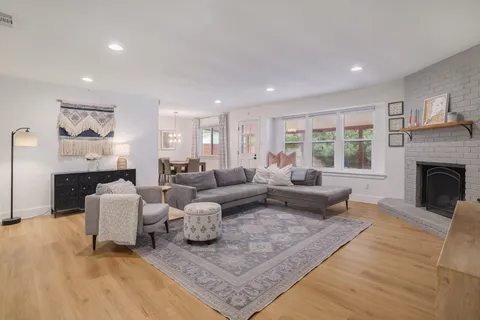 a living room with fireplace furniture and a wooden floor