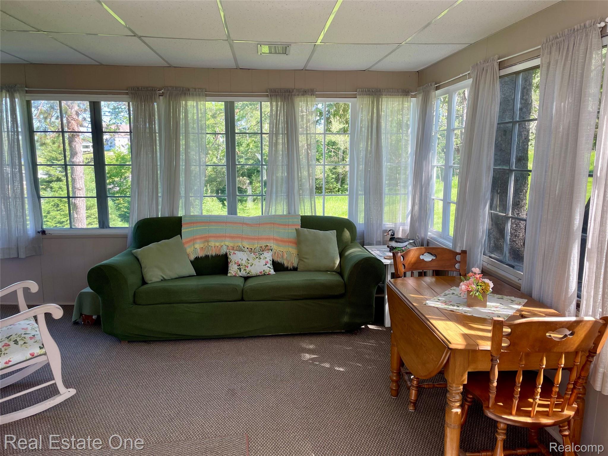 4160 Hawk Road Lincoln, MI 48742 - Photo 22 of 48 Sunroom featuring multiple transom windows, natural light, wall-to-wall carpeting, and a drop-ceiling