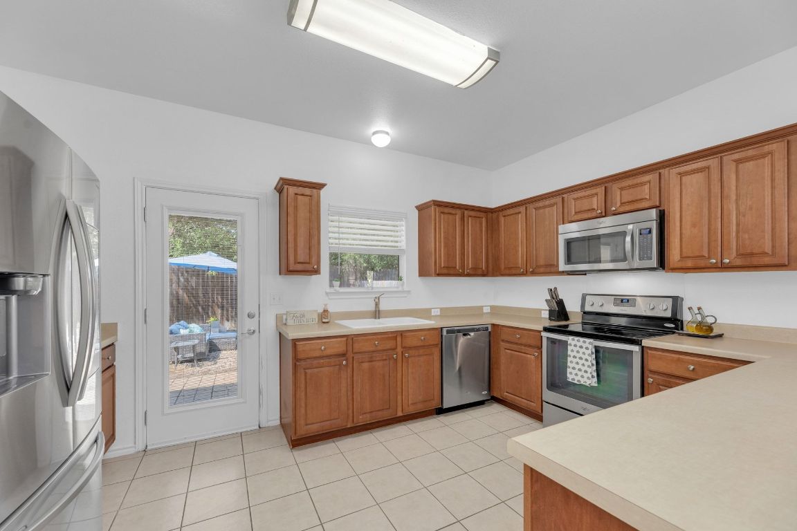 8901 Meridian Oak Lane Austin, TX 78744 - Photo 11 of 26 a kitchen with stainless steel appliances granite countertop a stove a sink dishwasher and a refrigerator