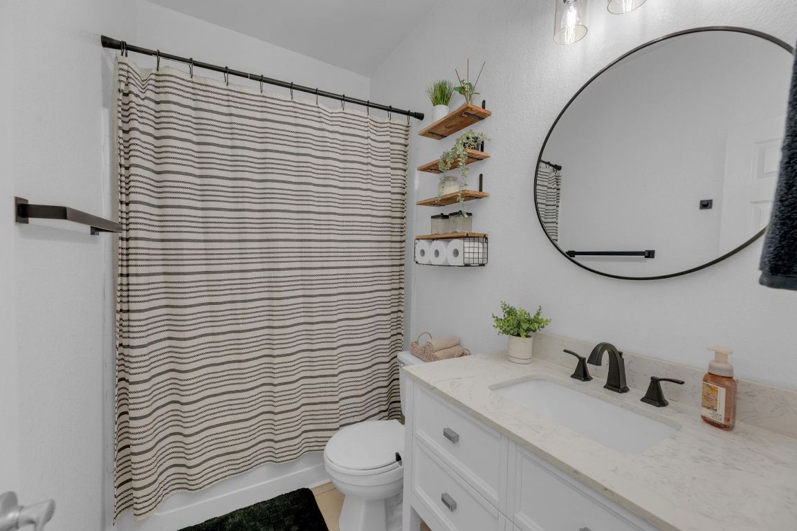 8901 Meridian Oak Lane Austin, TX 78744 - Photo 19 of 26 a bathroom with a sink a toilet and a mirror