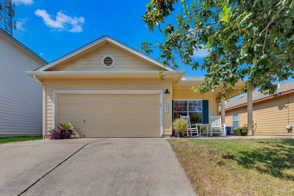 8901 Meridian Oak Lane Austin, TX 78744 - Photo 4 of 26 a front view of a house with a yard and garage
