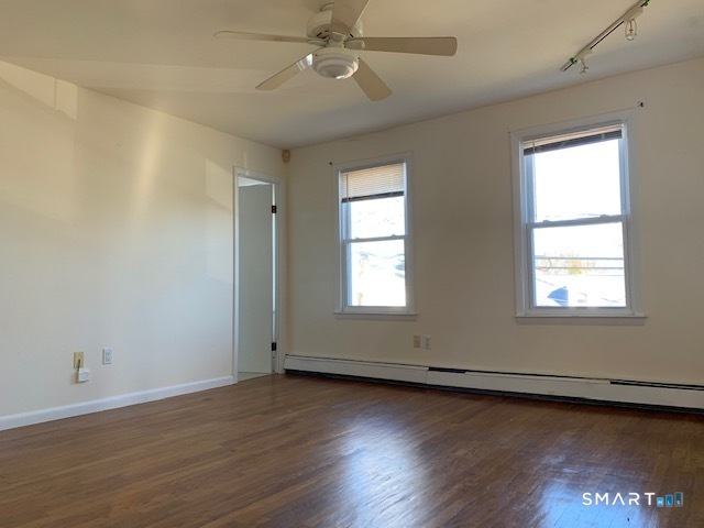23 Fairview Avenue, Unit 2 Norwalk, CT 06850 - Photo 2 of 15 an empty room with wooden floor and windows