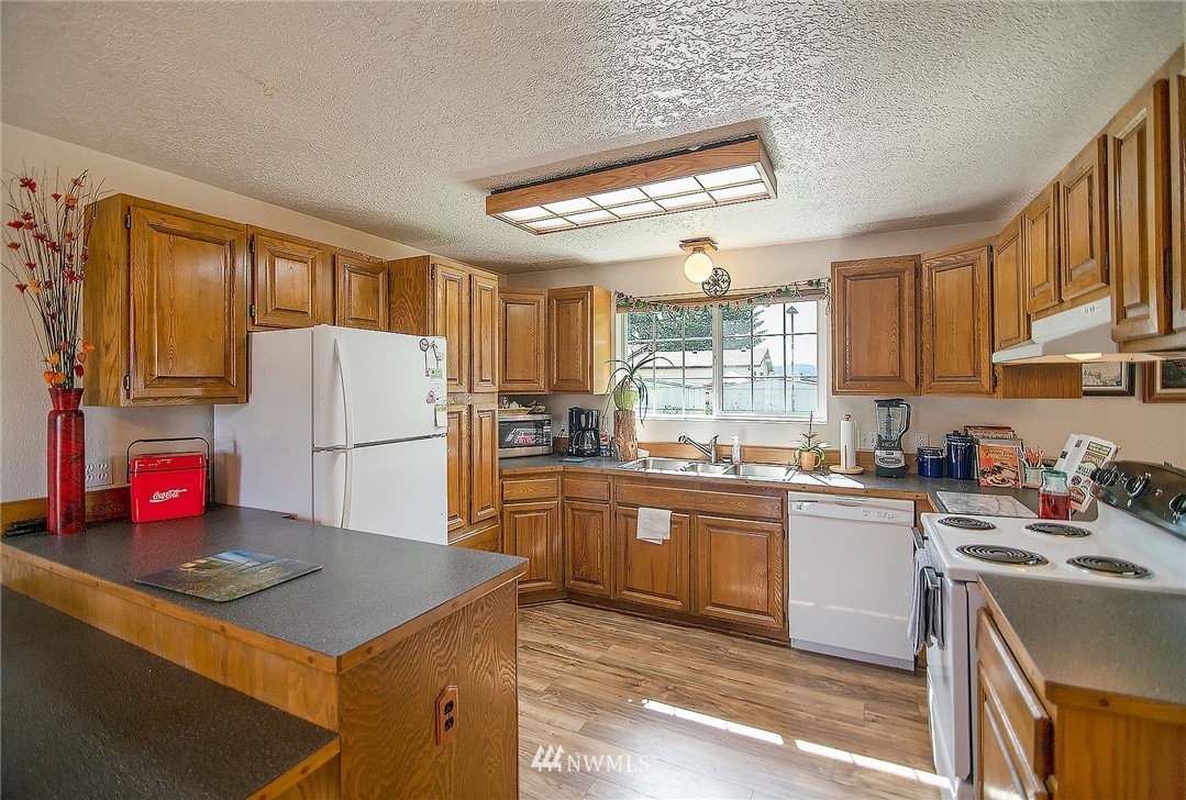 1009 Hilltop Road Winlock, WA 98596 - Photo 6 of 22 a kitchen with refrigerator cabinets and wooden floor