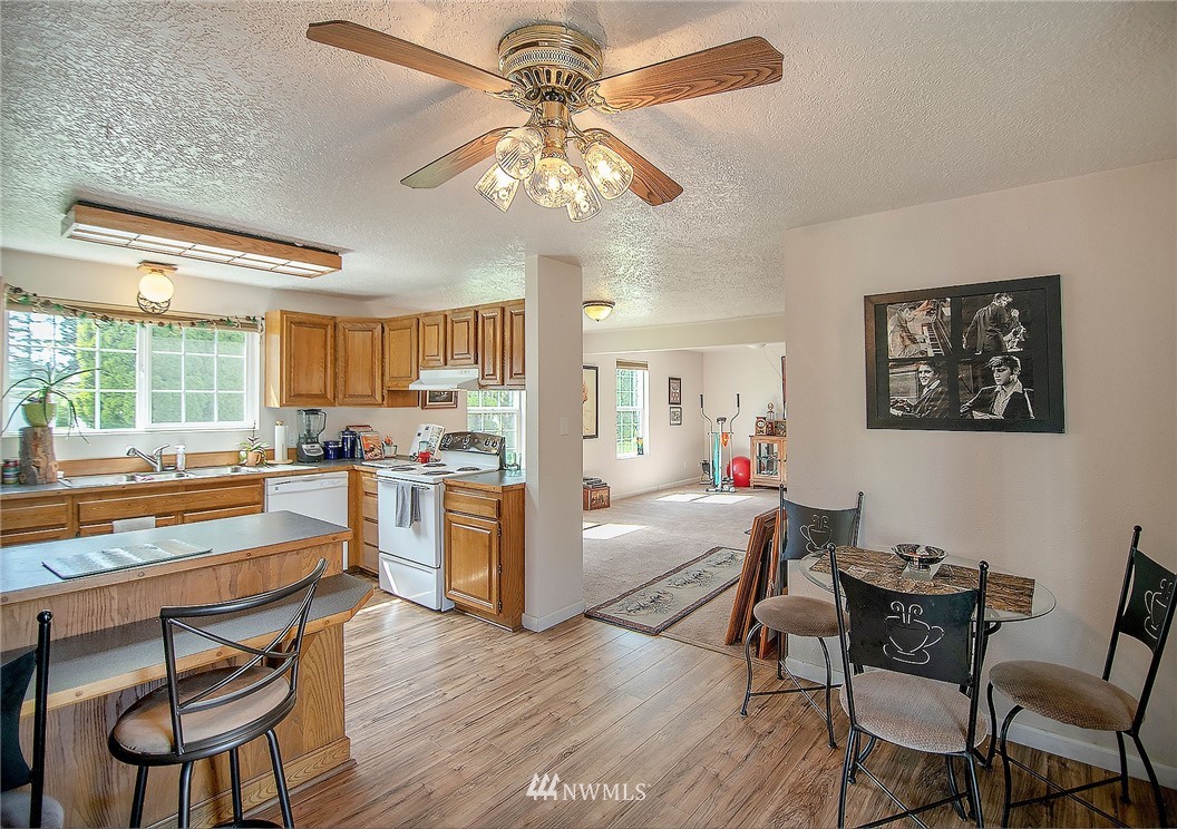 1009 Hilltop Road Winlock, WA 98596 - Photo 7 of 22 a kitchen with a dining table chairs refrigerator and cabinets