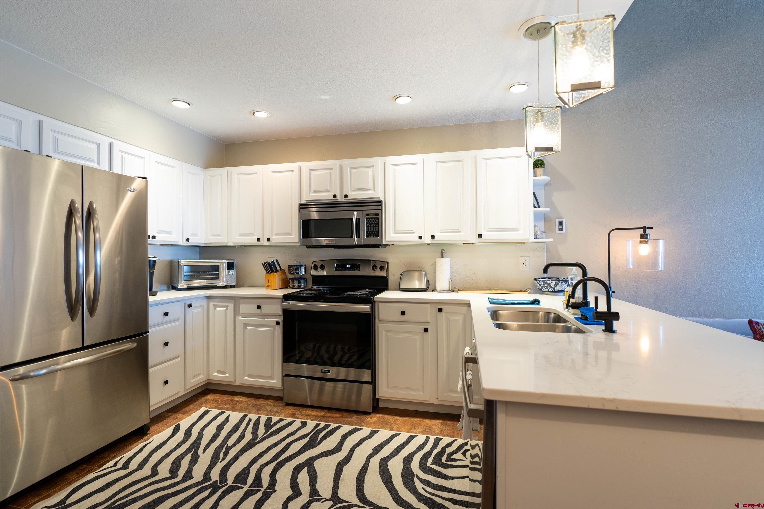 12 Snowmass Road, Unit 414 Crested Butte, CO 81225 - Photo 14 of 33 a kitchen with a sink stainless steel appliances a refrigerator and a sink
