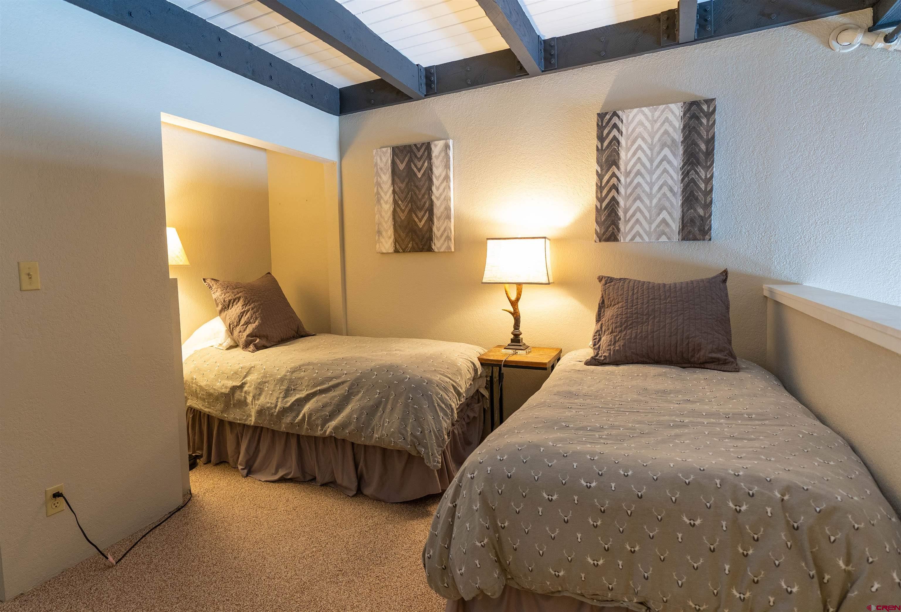 12 Snowmass Road, Unit 414 Crested Butte, CO 81225 - Photo 24 of 33 a bedroom with two beds and lamp