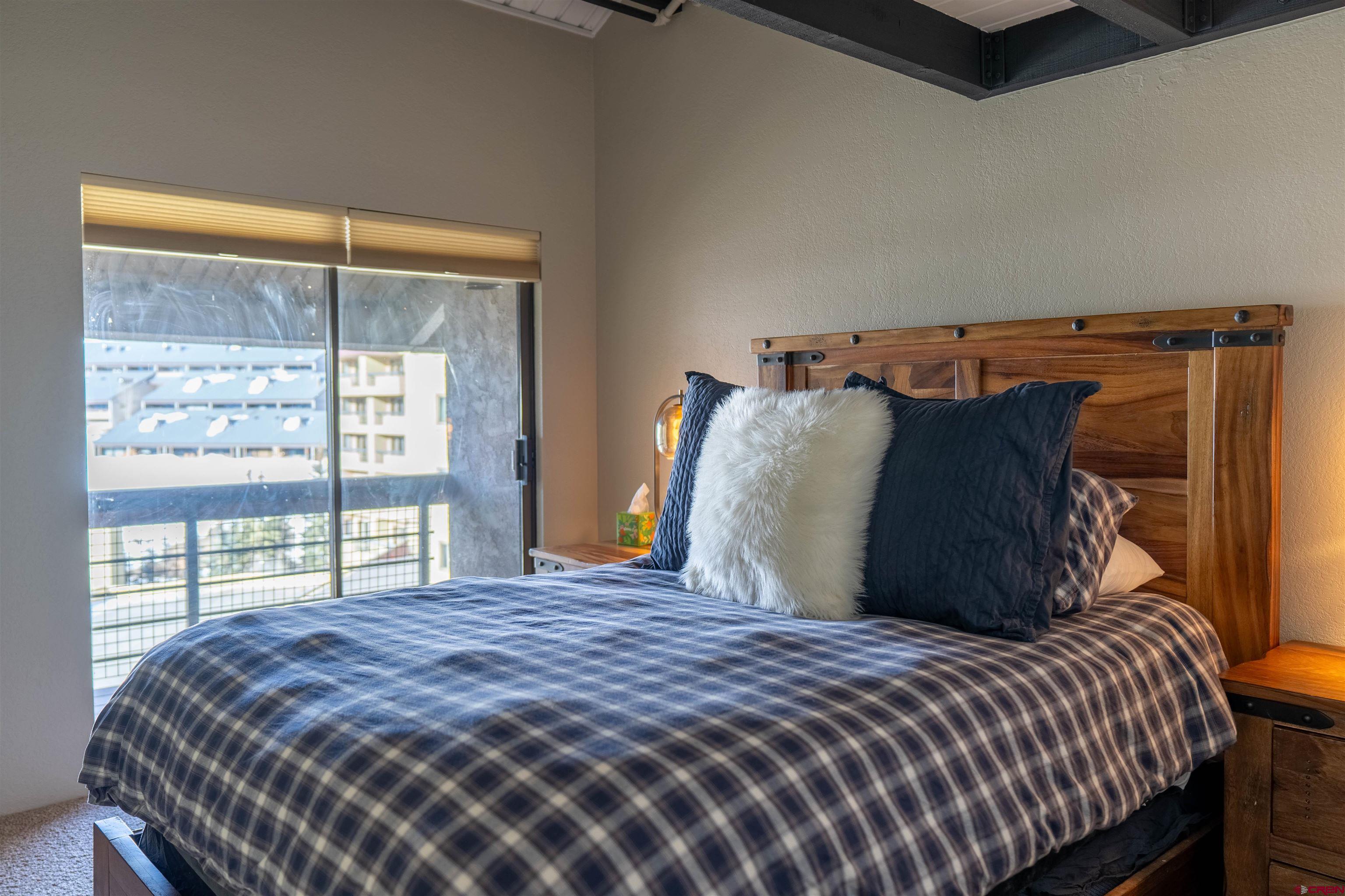12 Snowmass Road, Unit 414 Crested Butte, CO 81225 - Photo 26 of 33 a bedroom with a bed and a large window