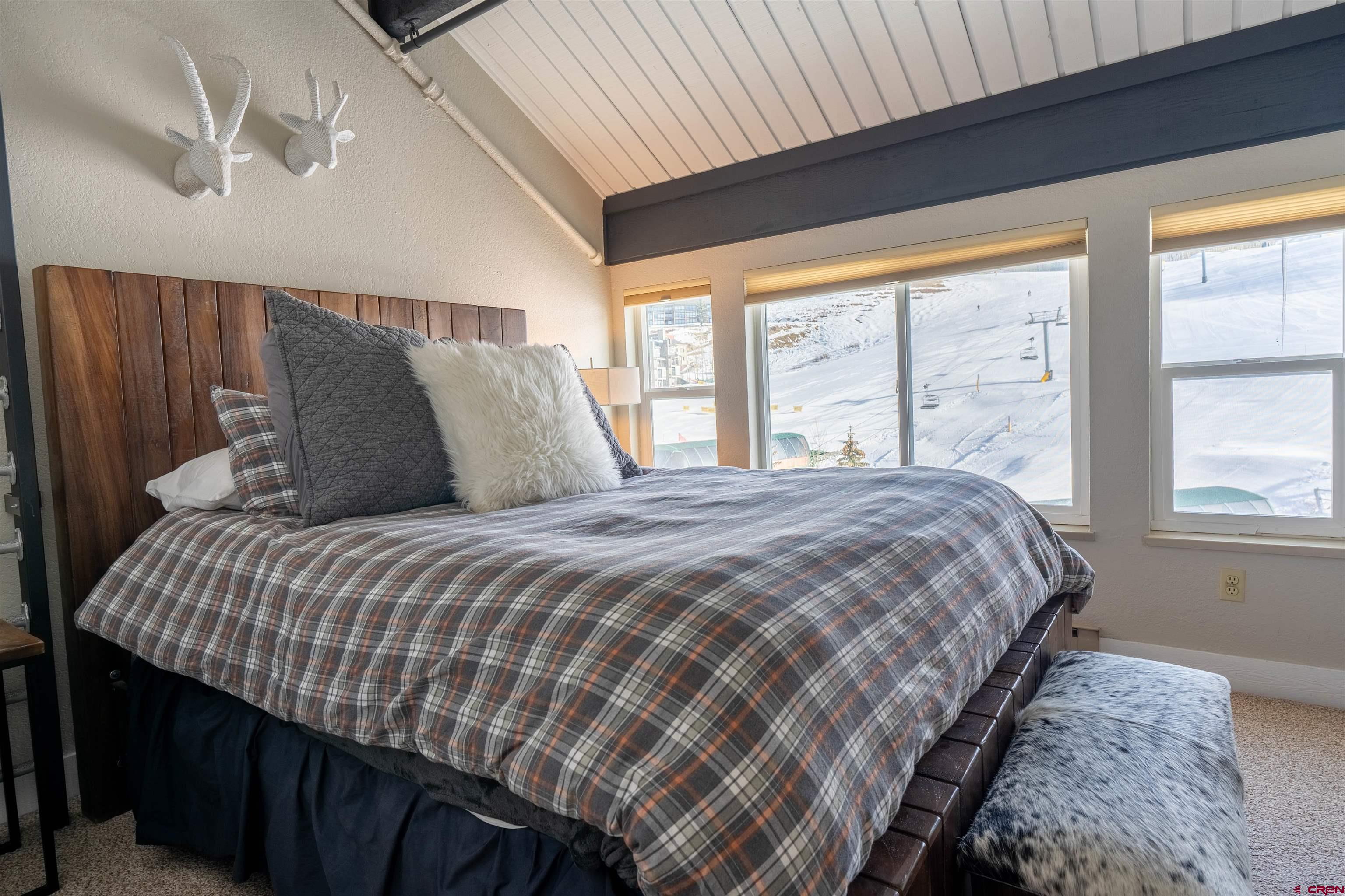 12 Snowmass Road, Unit 414 Crested Butte, CO 81225 - Photo 28 of 33 a bedroom with a large bed and a large window