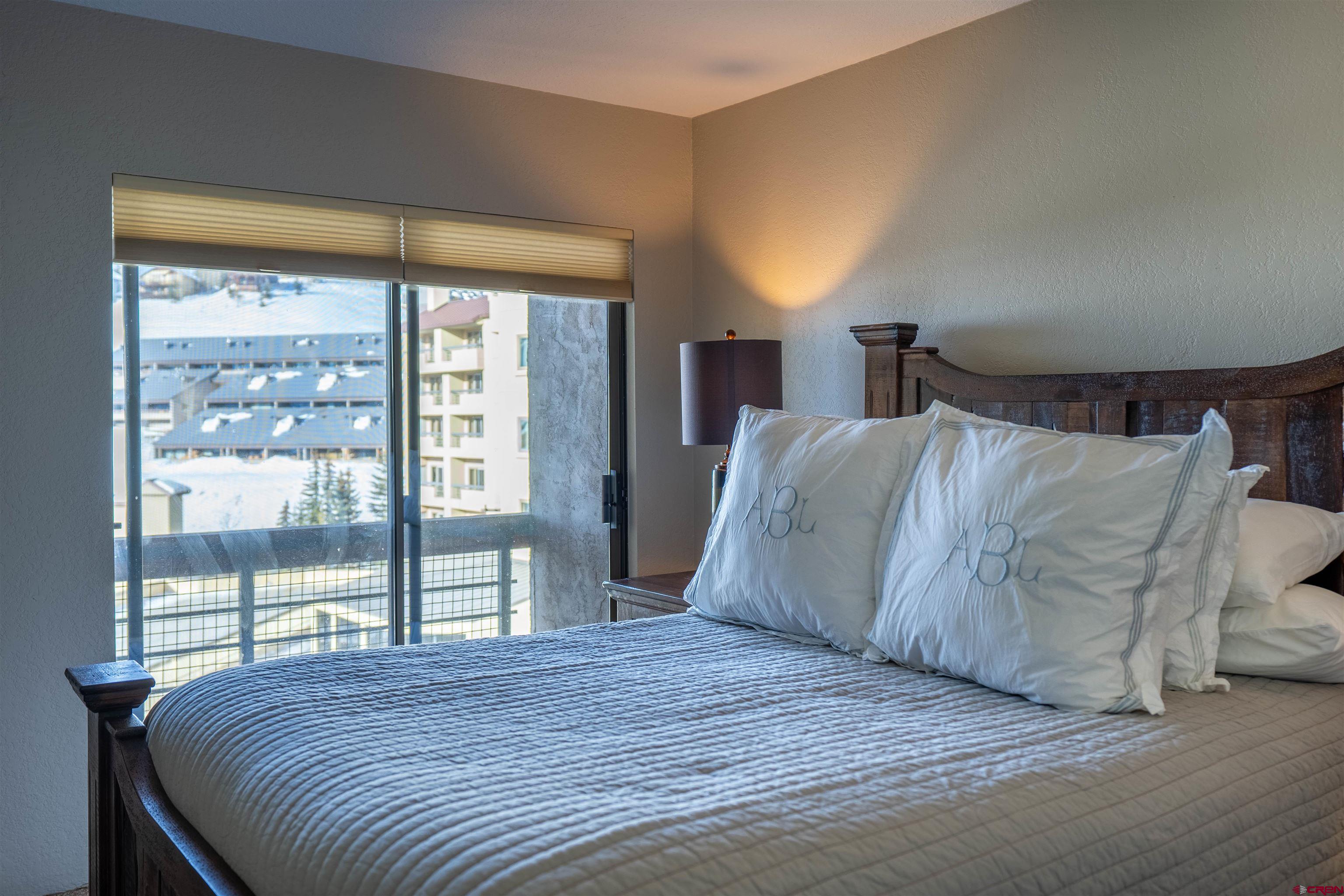 12 Snowmass Road, Unit 414 Crested Butte, CO 81225 - Photo 30 of 33 a bedroom with a large bed and a large window