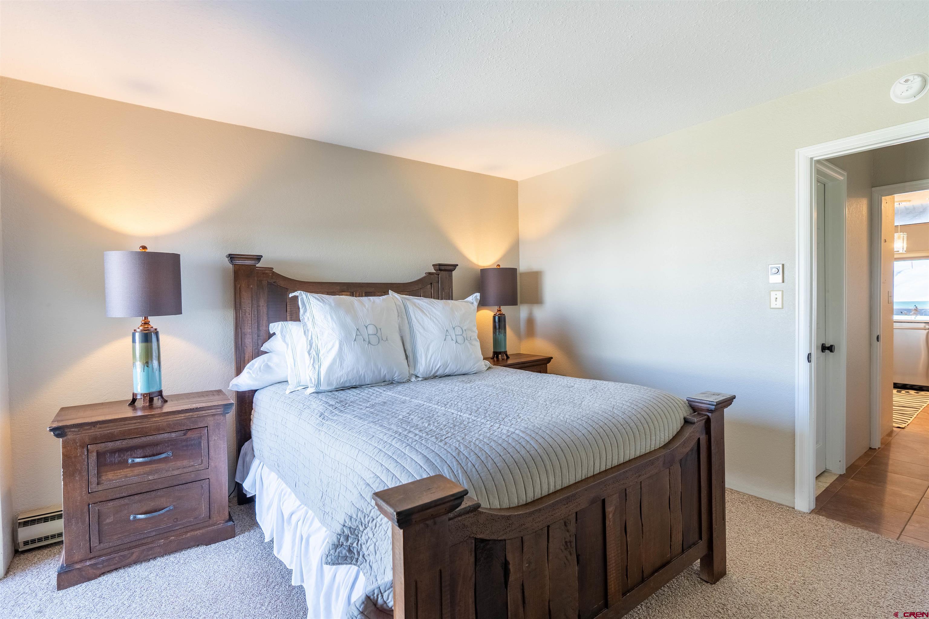 12 Snowmass Road, Unit 414 Crested Butte, CO 81225 - Photo 31 of 33 a bedroom with a bed and a lamp on dresser