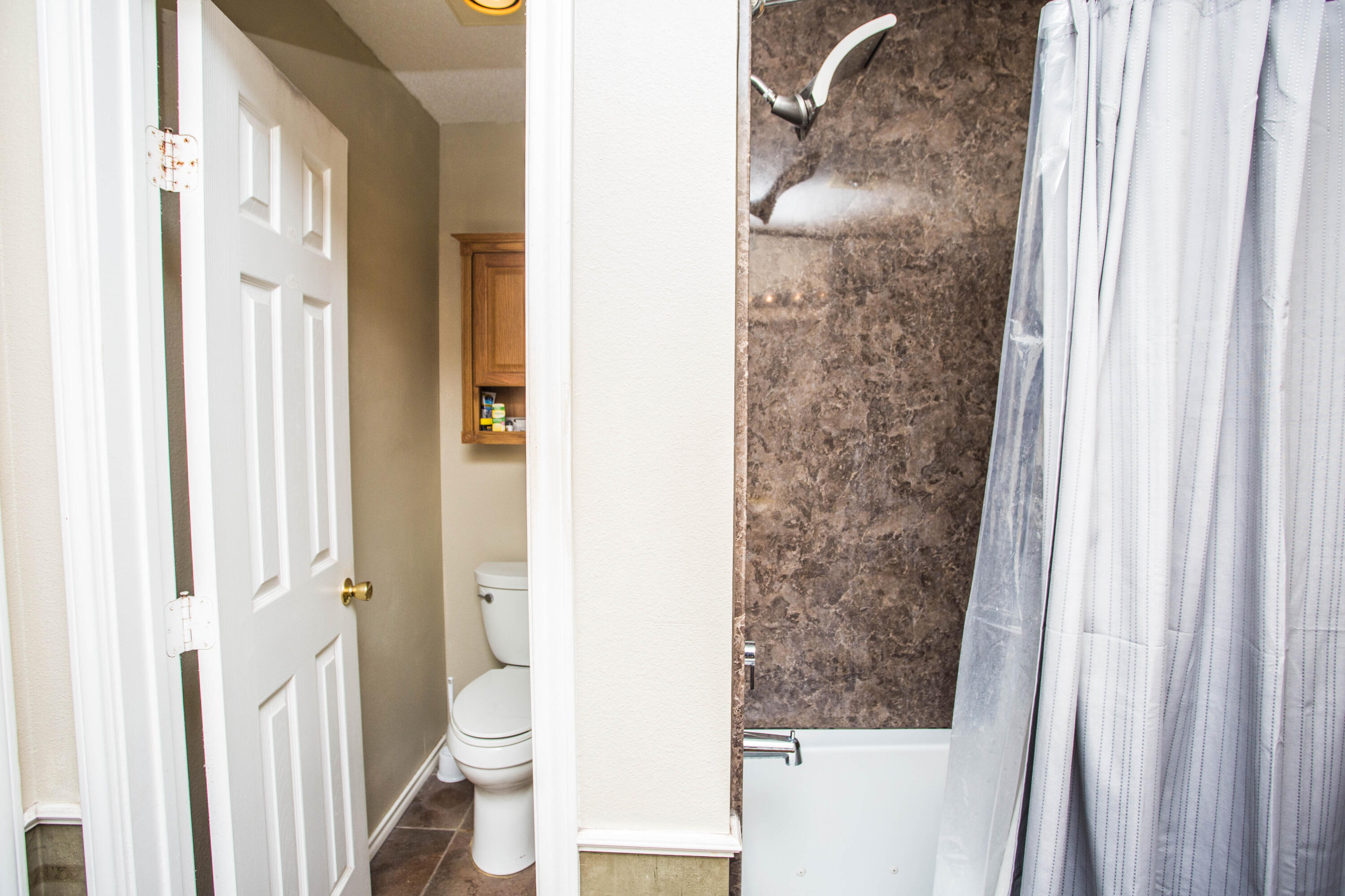 906 Xavier Street, Unit 1 Lubbock, TX 79403 - Photo 18 of 46 a bathroom with a granite countertop shower and a toilet