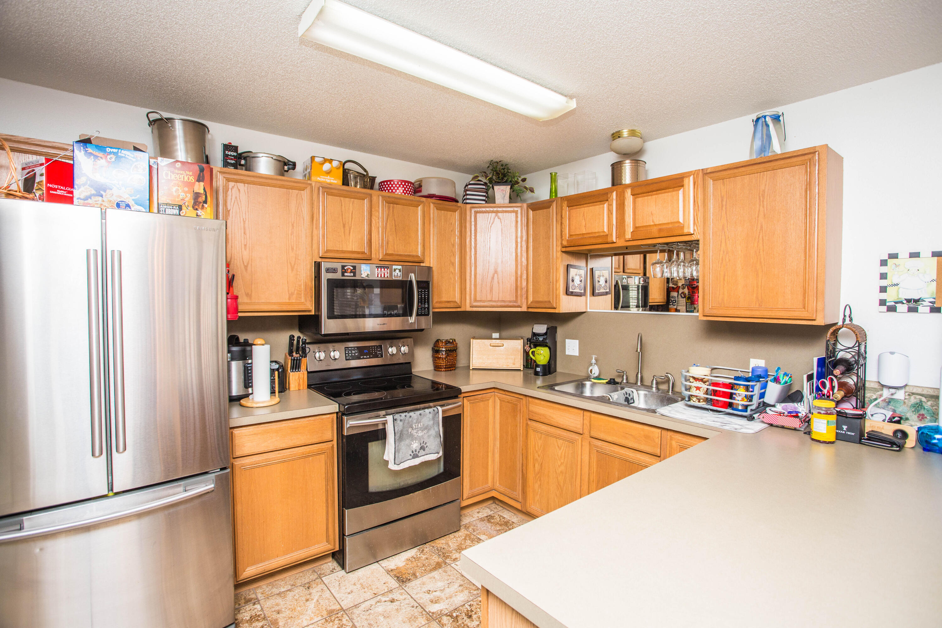906 Xavier Street, Unit 1 Lubbock, TX 79403 - Photo 37 of 46 a kitchen with granite countertop a refrigerator a sink a stove top oven and cabinets