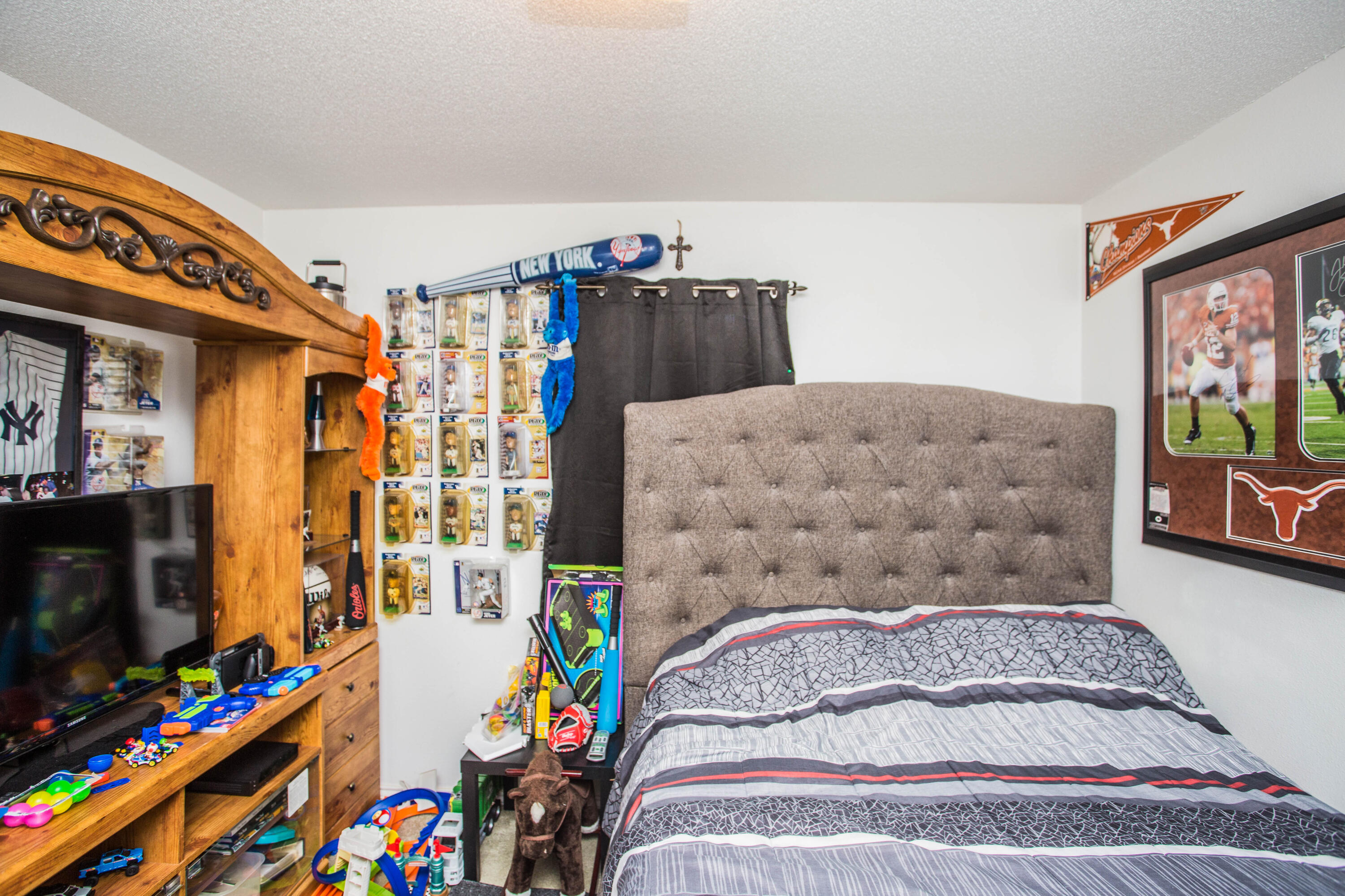 906 Xavier Street, Unit 1 Lubbock, TX 79403 - Photo 9 of 46 a bedroom with a bed and a flat screen tv