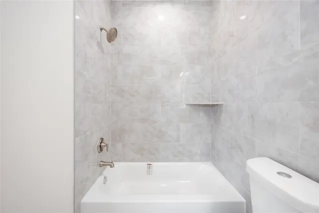 a bathroom with a white bath tub and a white sink