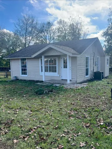 a view of a house with yard and a large tree